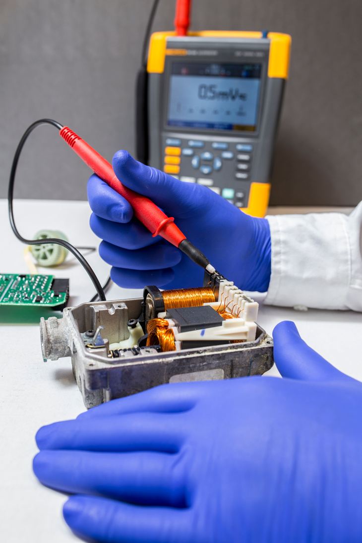 Engineer testing a device assembly with a multimeter